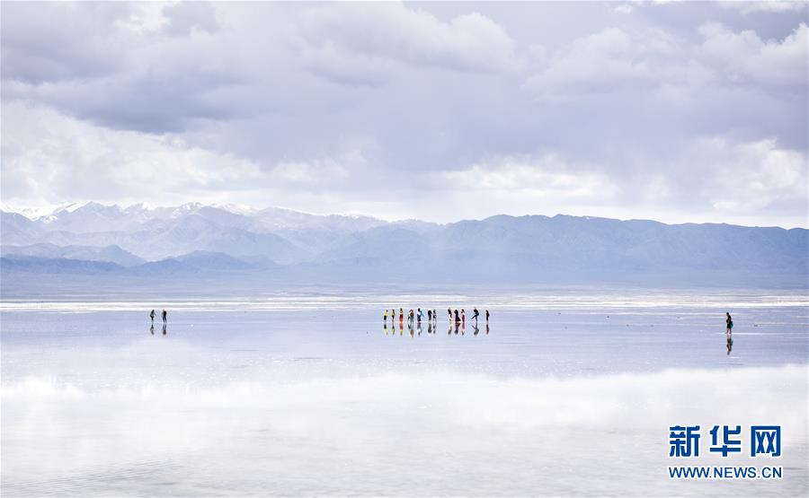 游客在青海省海西蒙古族藏族自治州茶卡盐湖景区内游玩（6月10日摄）。新华社记者 吴刚 摄 