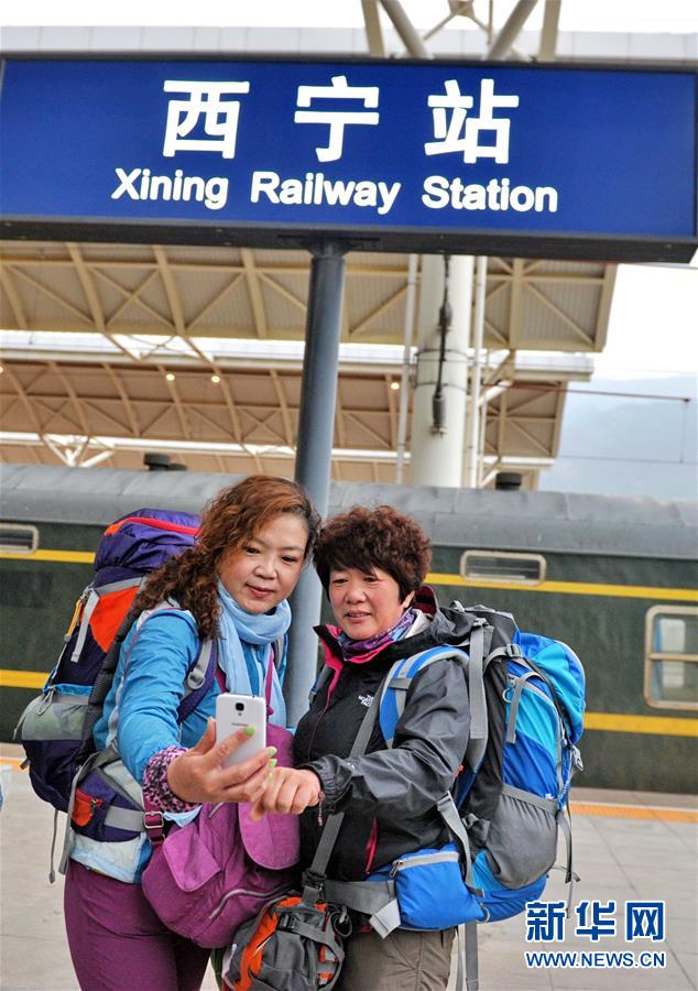乘坐Z918次列车从拉萨至西宁的游客在西宁站用手机自拍（5月28日摄）。新华社记者 张汝锋 摄 
